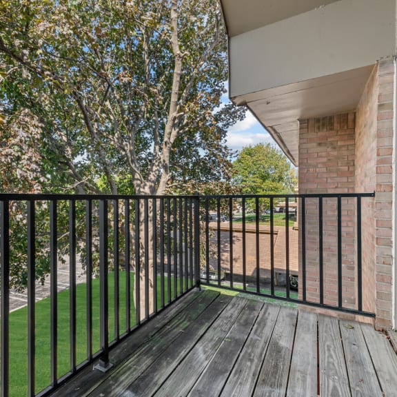 the view from the balcony of a home with a yard and trees