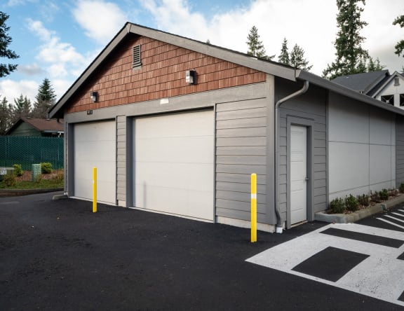 a garage with two garage doors on the side of a house