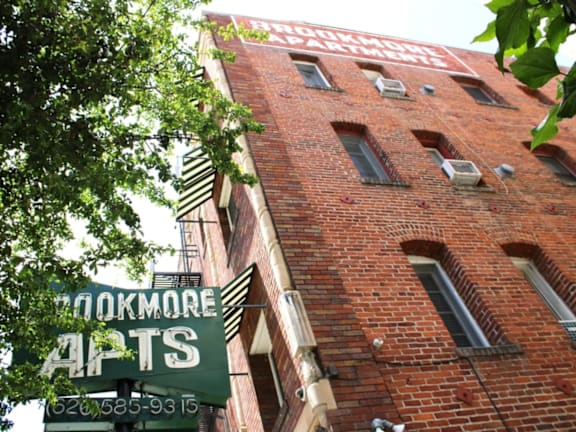 Brookmore Apartments brick building with a green sign that says