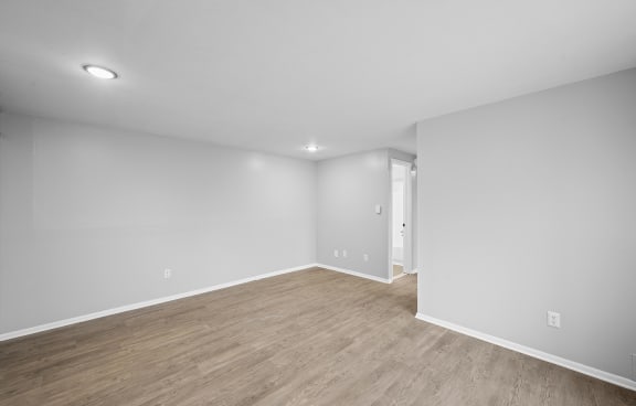 an empty living room with white walls and wood flooring
