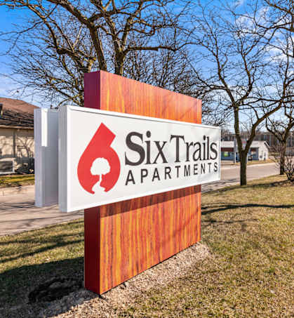 a sign for ski trails apartments on the side of a road