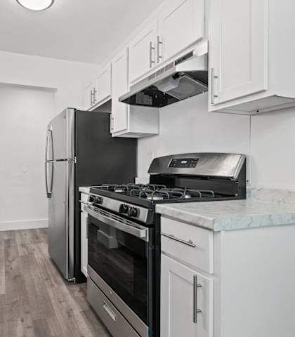 an all white kitchen with stainless steel appliances and marble counter tops