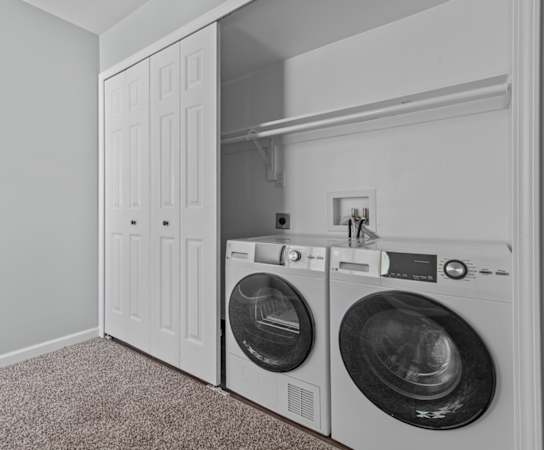 a washer and dryer in a laundry room with a white closet