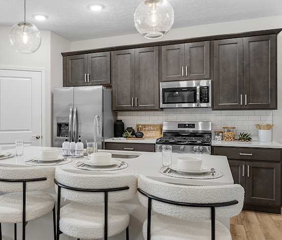 A kitchen with a white table and chairs and brown cabinets.