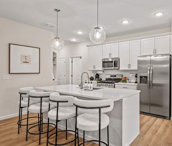 A modern kitchen with white cabinets and a central island.