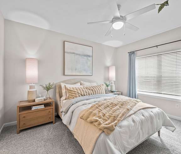 A bedroom with a large bed and a ceiling fan.