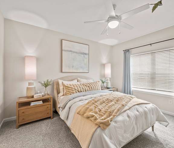 A bedroom with a large bed and a ceiling fan.