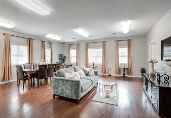 A living room with a grey couch and wooden floors.