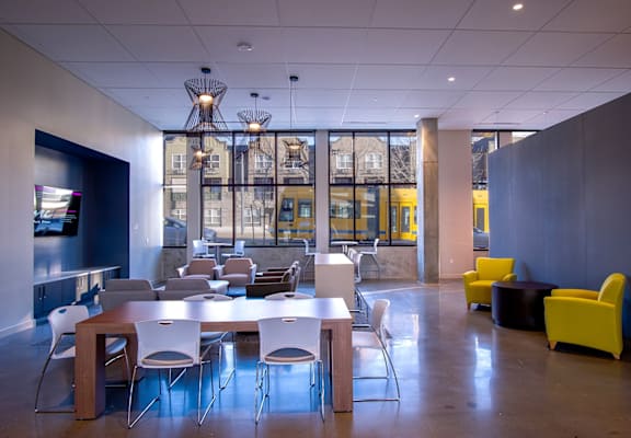 A modern dining room with a long table and chairs.