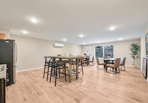 A kitchen with a dining table and chairs.