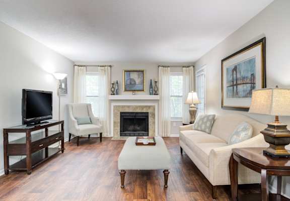 Pet-Friendly Apartments in Marietta– Wood Pointe Apartments – A living room with a fireplace and a television.