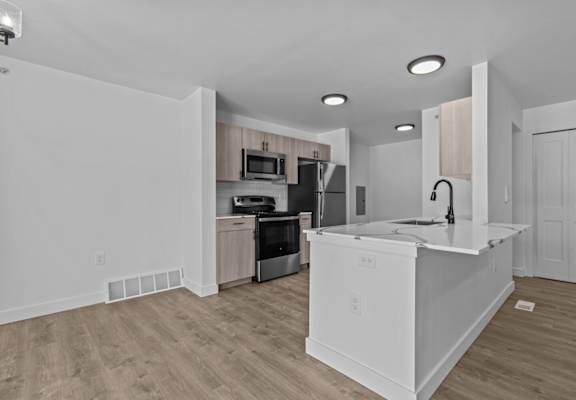 an empty kitchen with a large counter top and a sink