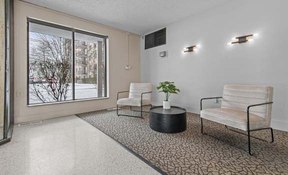 a living room with two chairs and a large window