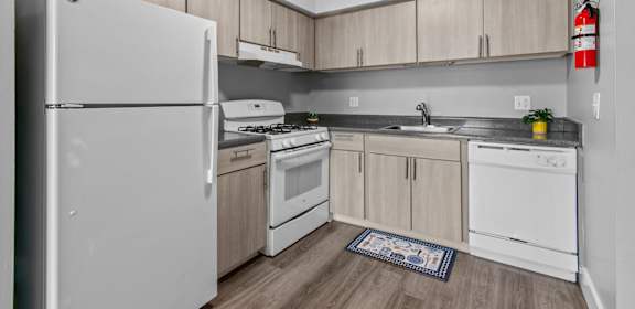 A kitchen with white appliances and wooden cabinets.