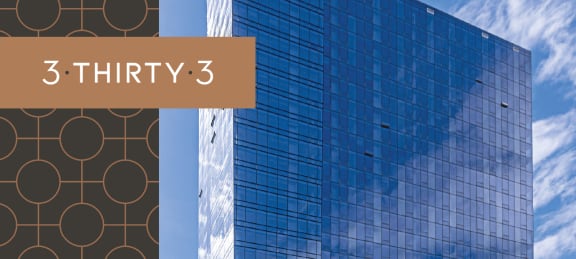 Exterior view of 3THIRTY3 Apartments, a modern building with sleek architecture and landscaped surroundings against a clear blue sky.