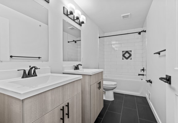 a white bathroom with two sinks and a toilet