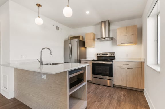 a renovated kitchen with a large island and stainless steel appliances