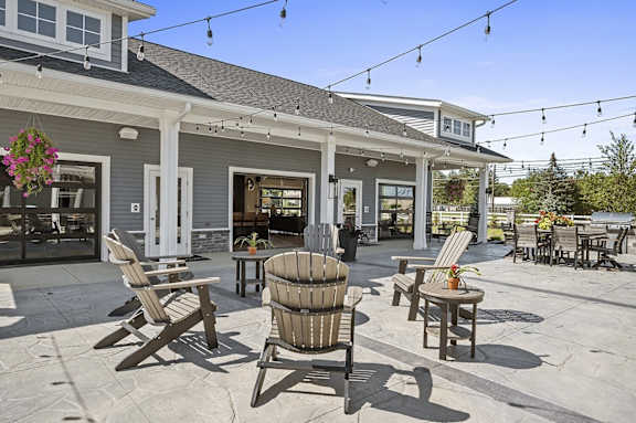 A patio with chairs and a table is set up outside a house.