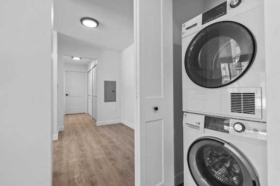 a white washer and dryer in a white laundry room with a white door