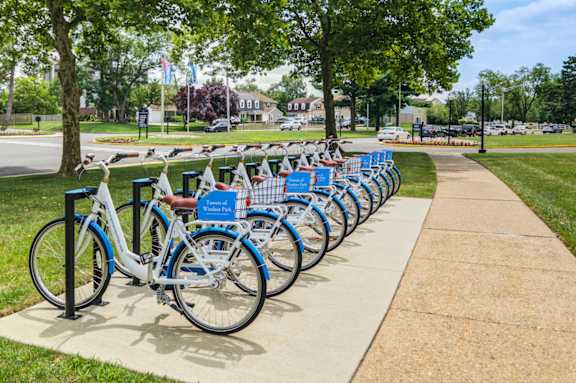 A row of bicycles are parked in a bike rack.