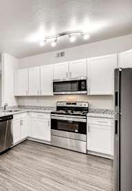 A spacious kitchen with white cabinets and stainless steel appliances.
