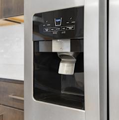 a stainless steel refrigerator with a coffee dispenser in a kitchen