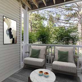 A small balcony with a table and two chairs.