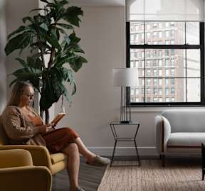 a woman sitting in a living room reading a book