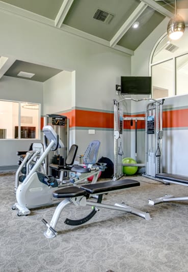 a gym with exercise equipment and a tv on the wall at The Edge of Germantown, Memphis, TN