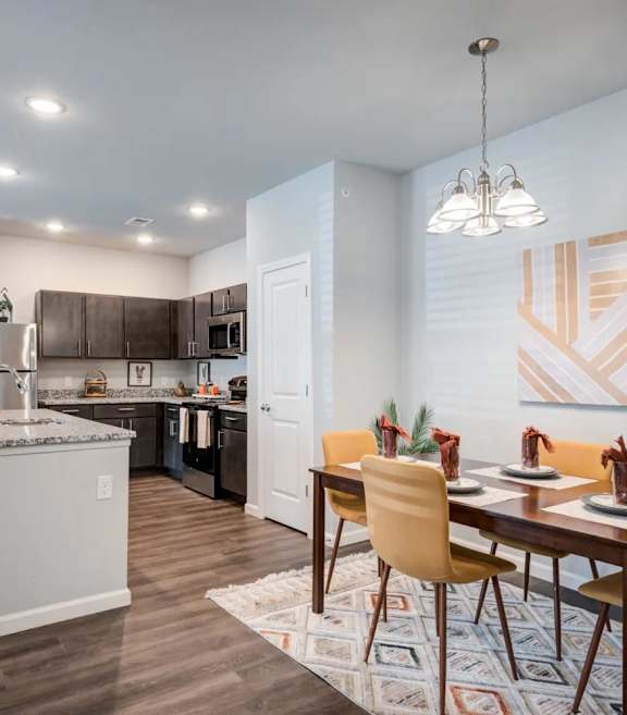 A modern kitchen with a dining table set for four.