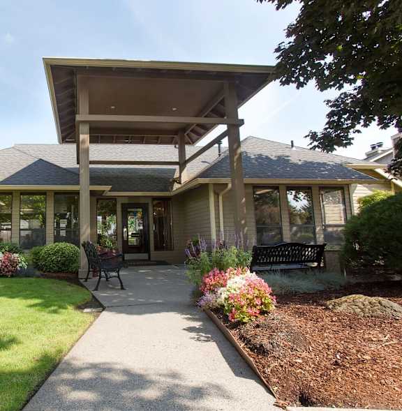 A house with a front yard and a bench.