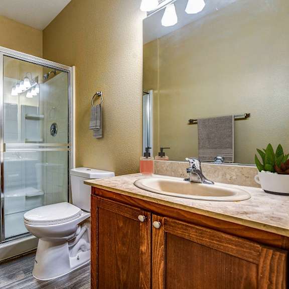 A bathroom with a toilet, sink, and shower.