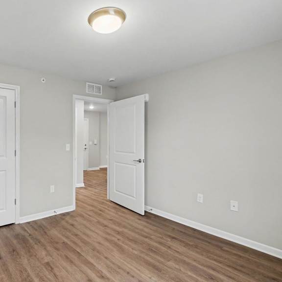 A room with two white doors and a wooden floor.