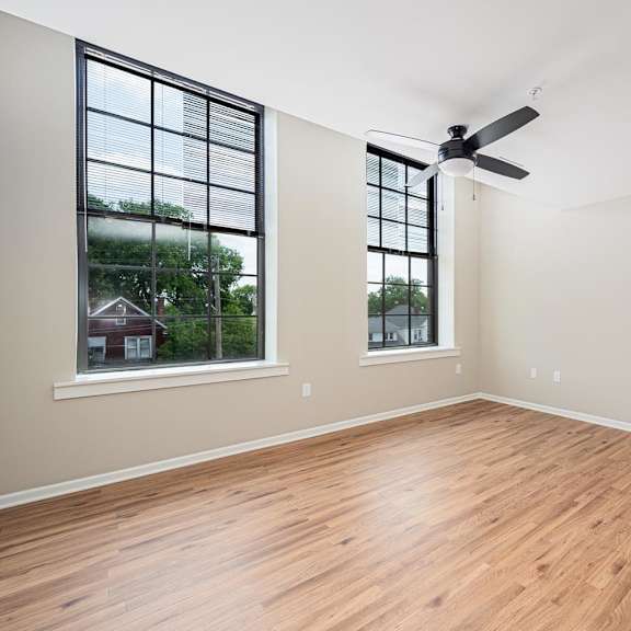A room with wooden floors and a ceiling fan.