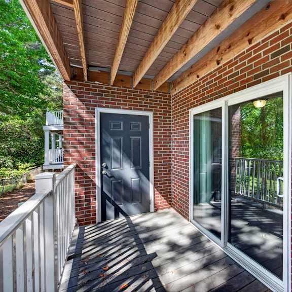 A red brick house with a black door and a glass window.