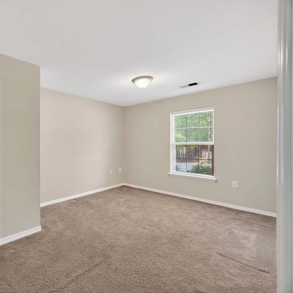 A room with a white door and carpeted floor.
