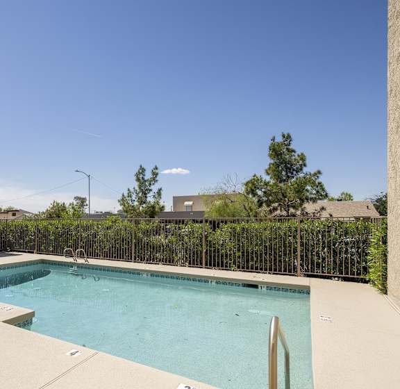 A pool surrounded by a fence and a building.