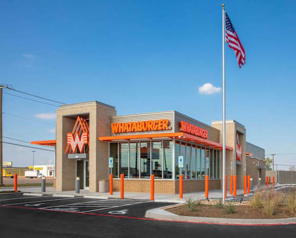 A Whataburger restaurant with an American flag in front.