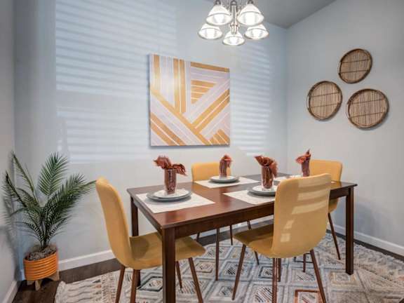A dining room with a wooden table and chairs.