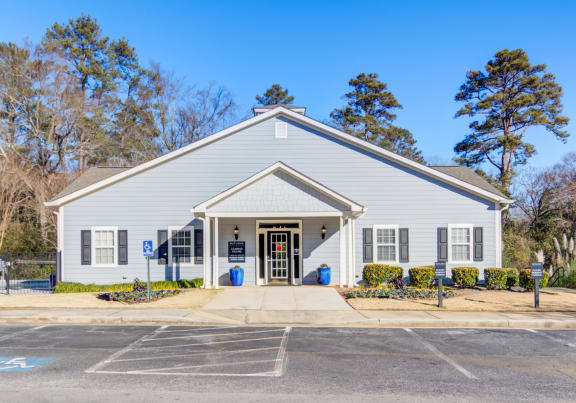 the front of a white church building with a sidewalk and parking lot