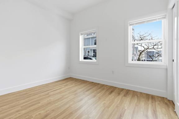 A room with a window and a picture on the wall.
