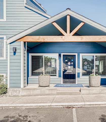 a blue building with a wooden roof and glass doors