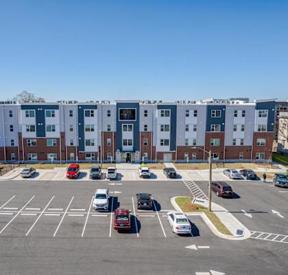 an aerial view of an empty parking lot in front of an apartment building