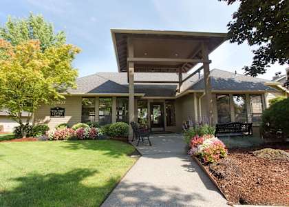 A house with a front yard and a bench.