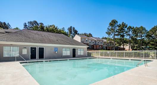 A swimming pool in front of a building with a blue sign.