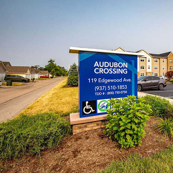 a sign in a parking lot with a building in the background