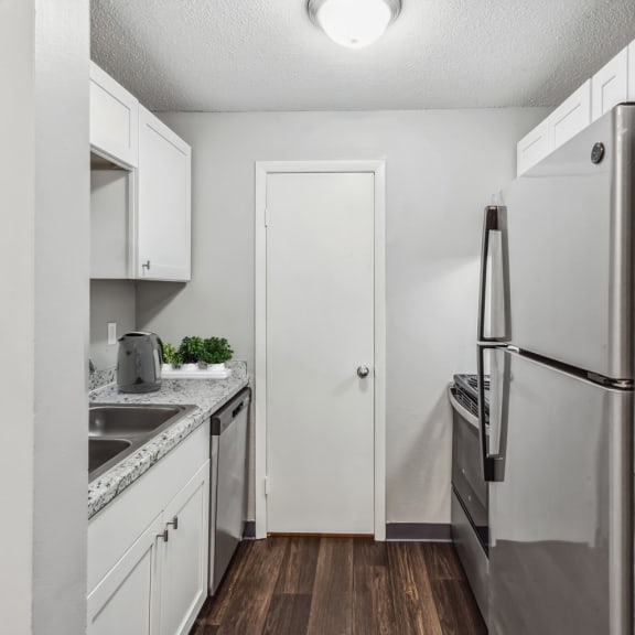 a kitchen with white cabinetry and stainless steel appliances