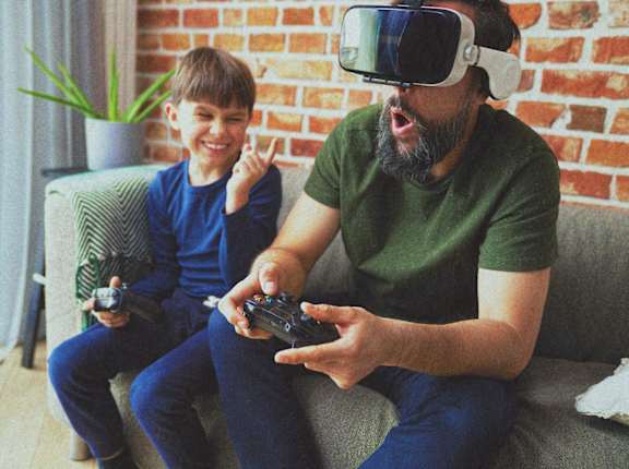 a man and a boy wearing virtual reality goggles playing a video game