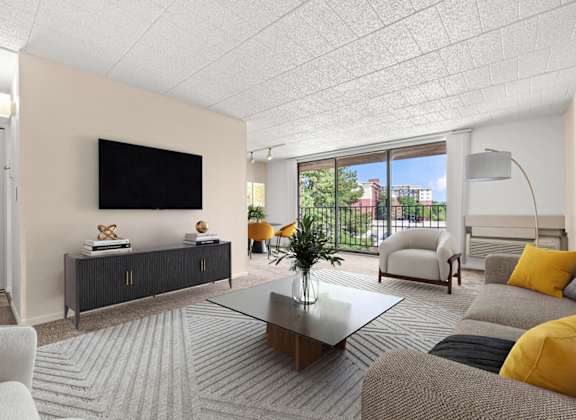 A living room with a flat screen TV mounted on the wall.
