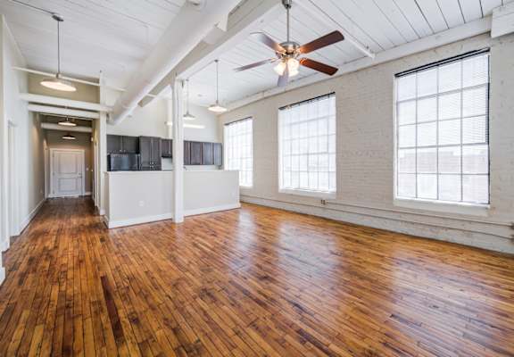 A room with wooden floors and a ceiling fan.